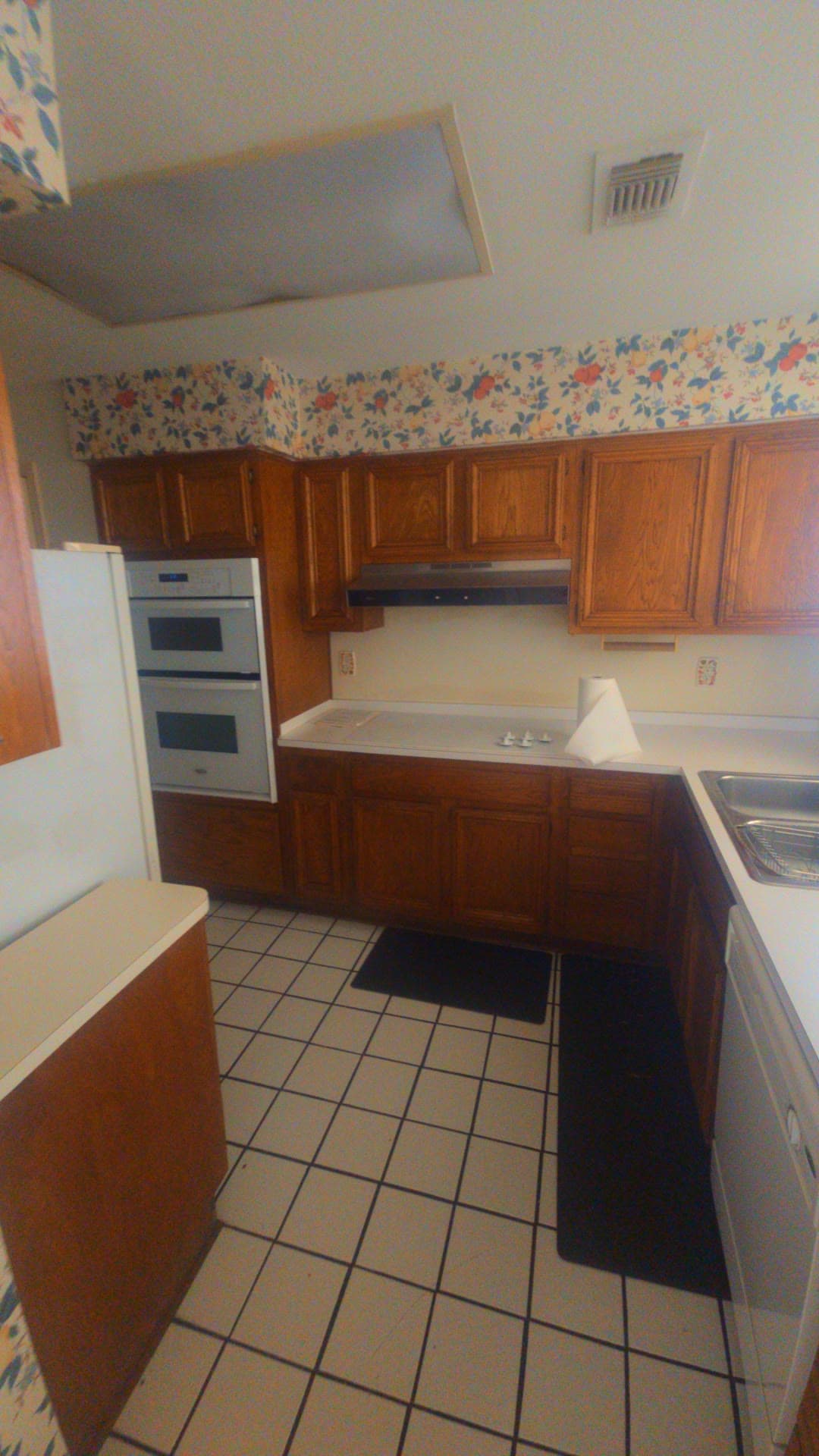 Dark wood kitchen cabinets and a tiled counter the day we took the keys