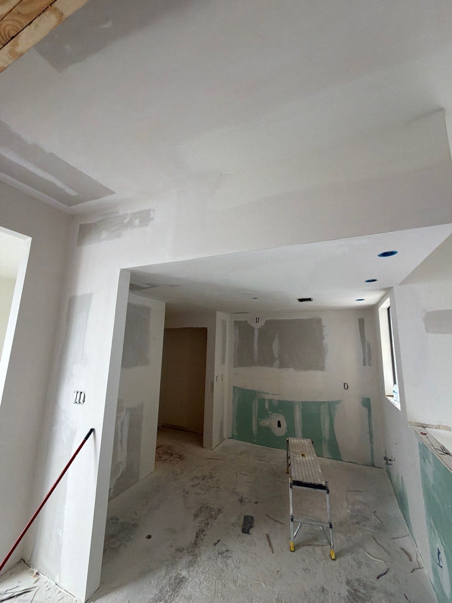 Kitchen taking shape with fresh drywall and recessed lighting