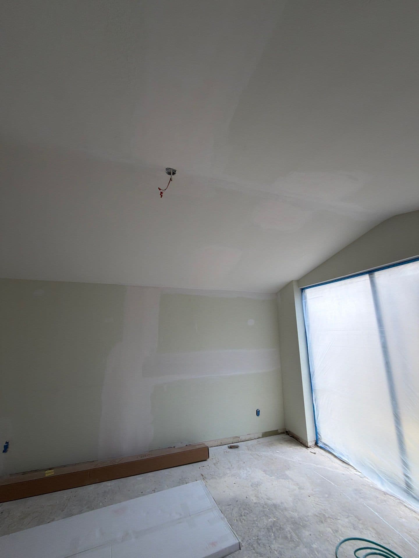 Skim-coated bedroom with vaulted ceiling, slider masked for paint