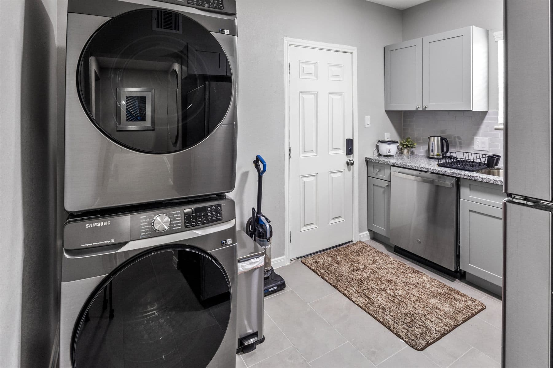 Kitchen with granite counters, gray cabinets and black stove, finished by the Reborn group