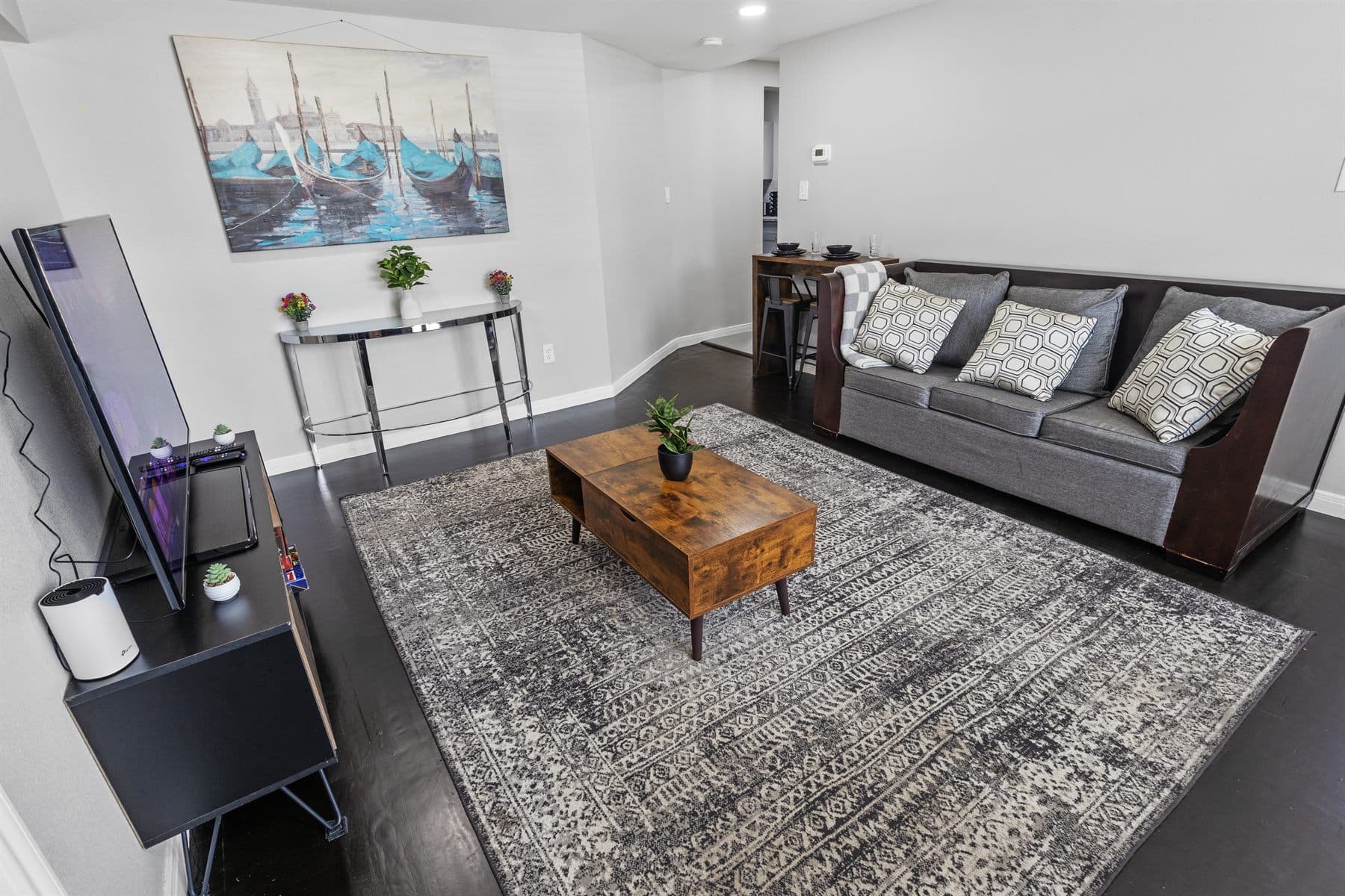Living room with gray sectional, wood coffee table and framed art, finished by the Reborn group