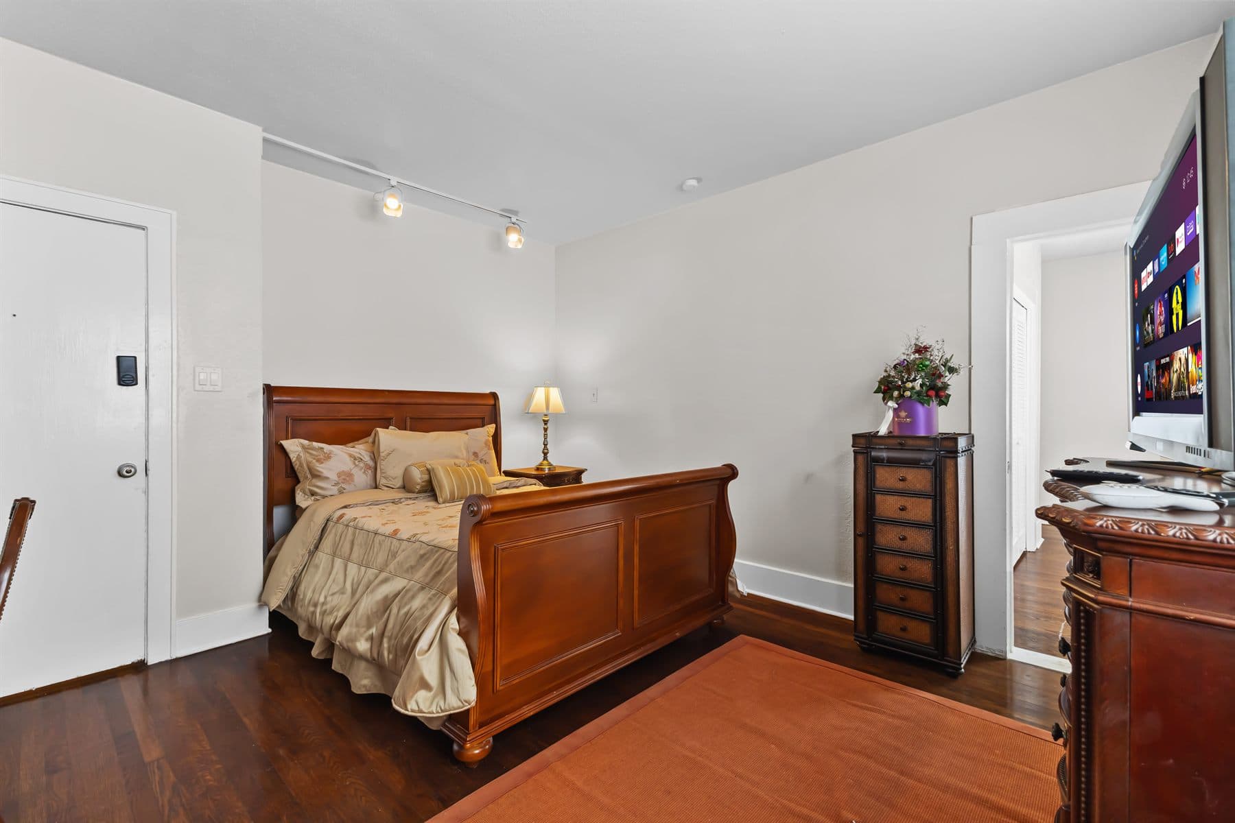 Bedroom with traditional dark wood furniture and red patterned rug, finished by the Reborn group