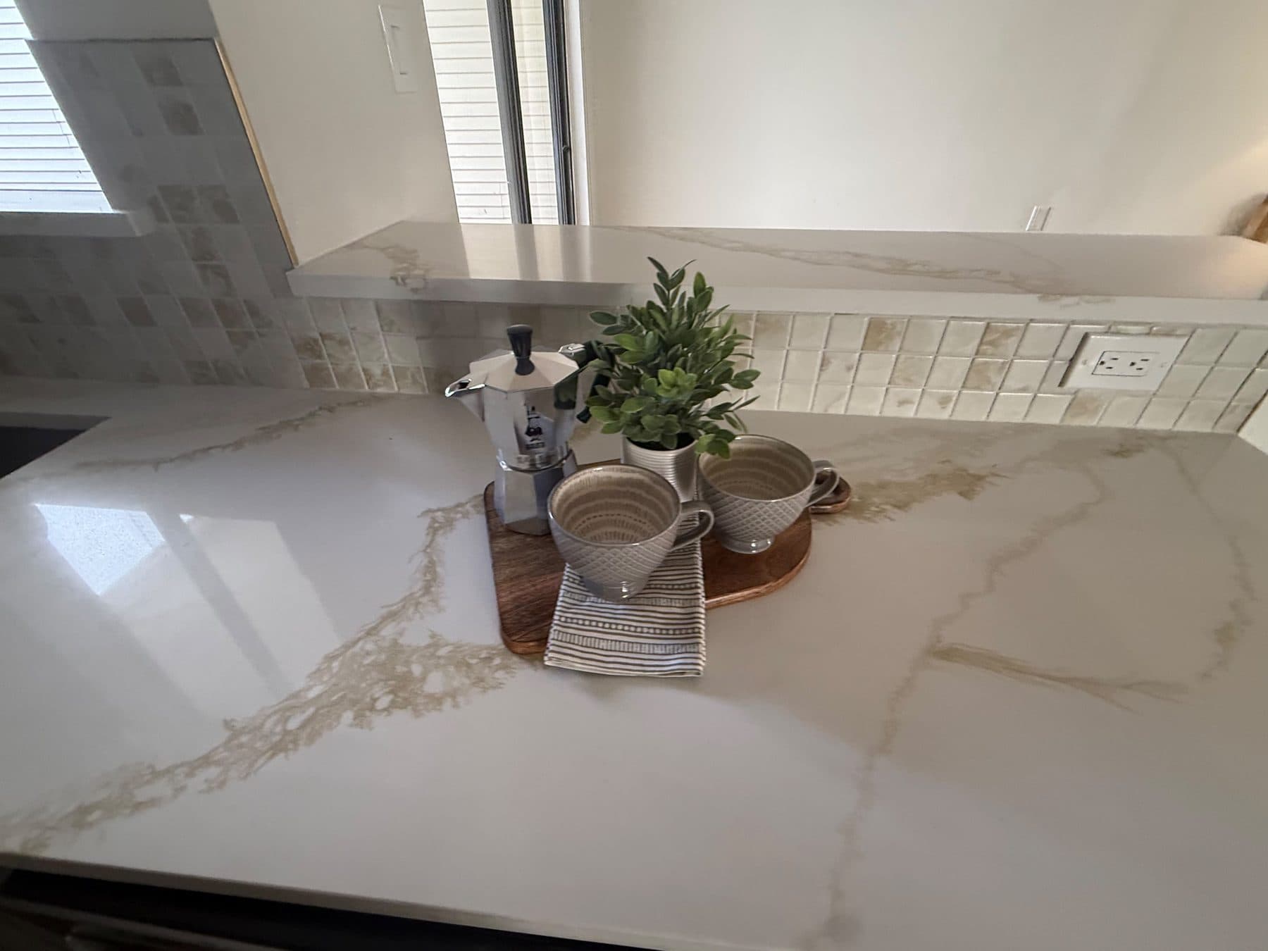 Quartz kitchen counter styled with a coffee set, staged for listing and finished by the Reborn group