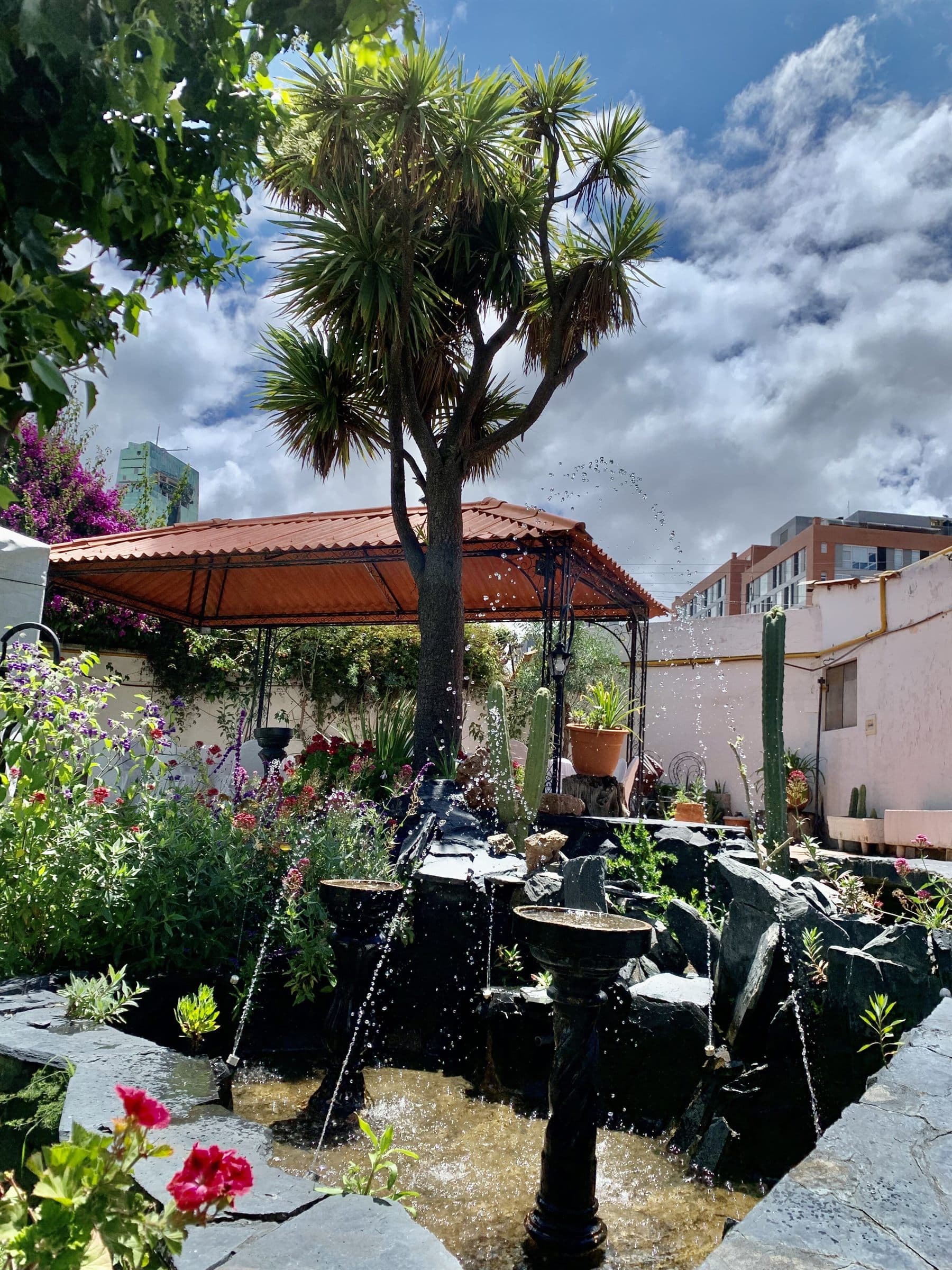 Garden patio with wrought iron gazebo, stone fountain and flowering beds, finished by the Reborn group