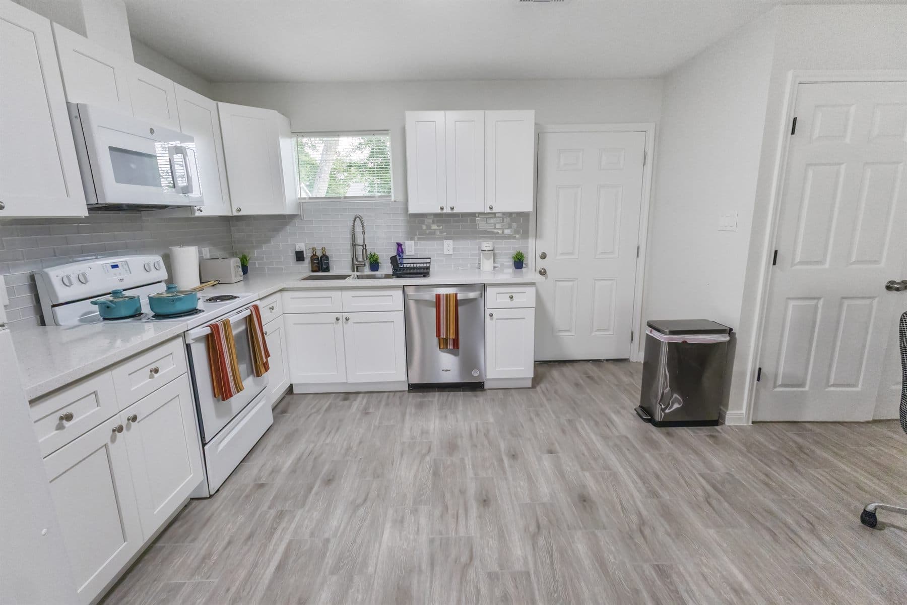 White galley kitchen with laminate counters, finished by the Reborn group